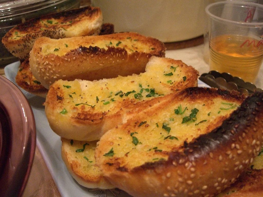 garlic bread being warmed up pieces of garlic bread in a plate